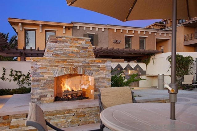 patio terrace at dusk with an outdoor stone fireplace