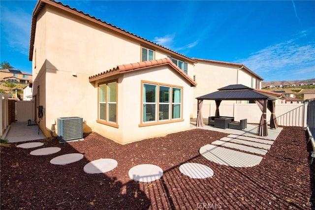 back of property featuring central AC unit, a gazebo, and a patio area