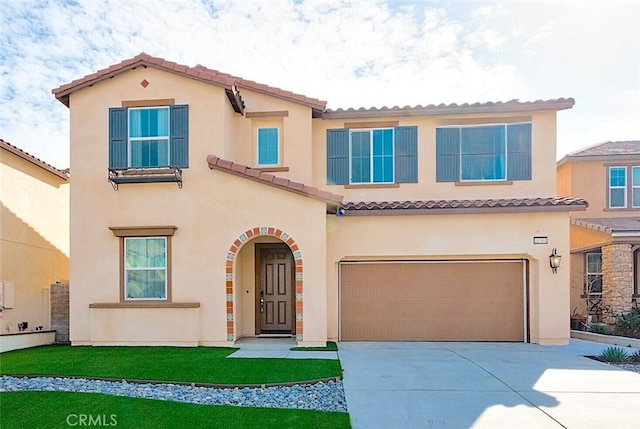 mediterranean / spanish home with a garage and a front lawn