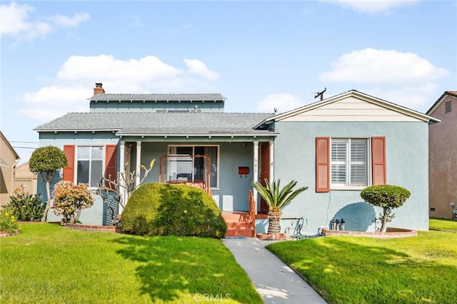 bungalow-style house featuring covered porch and a front yard