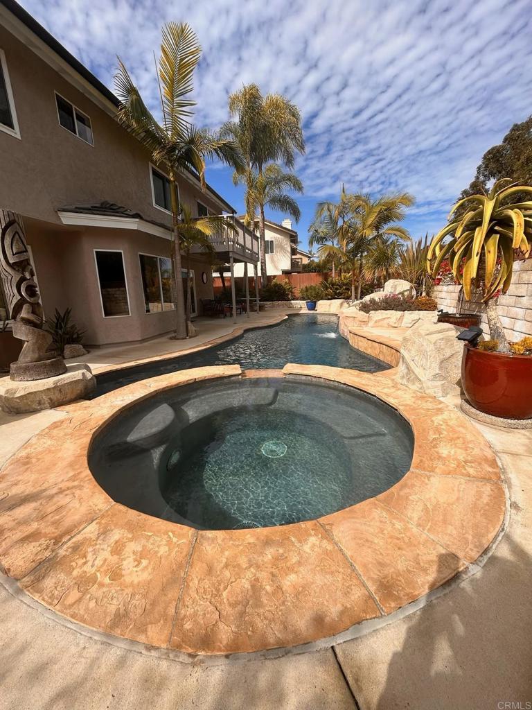 view of swimming pool with an in ground hot tub and pool water feature