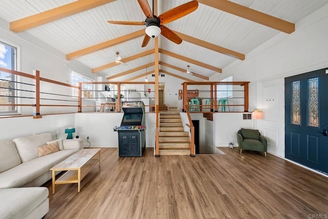 living room featuring ceiling fan, hardwood / wood-style floors, and vaulted ceiling with beams