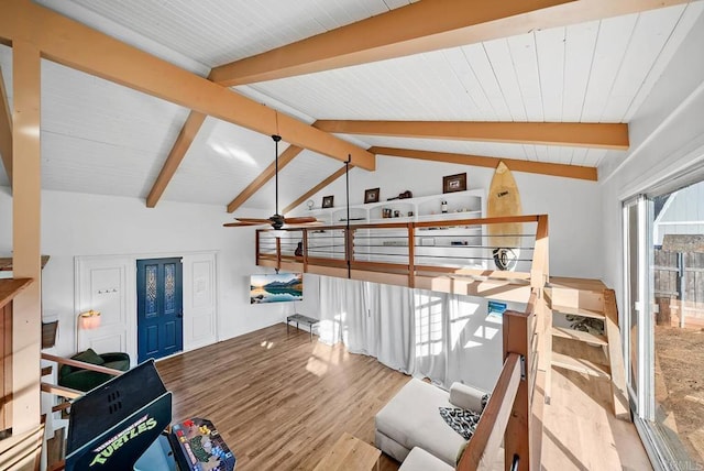 interior space with ceiling fan, vaulted ceiling with beams, and light hardwood / wood-style floors