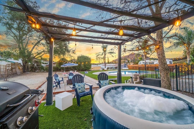 pool at dusk featuring grilling area and a pergola