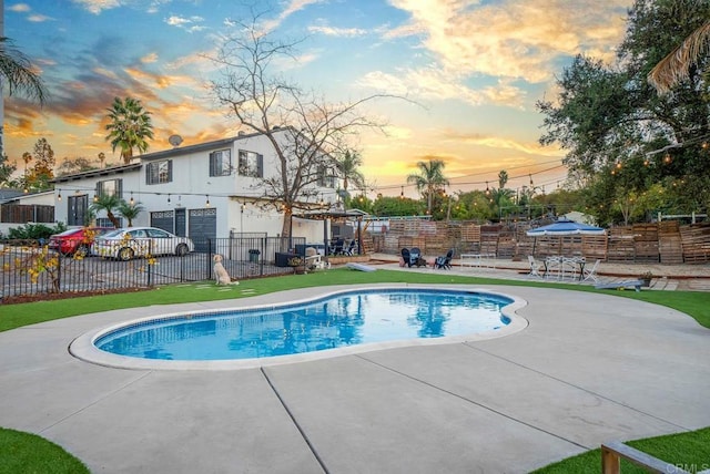 pool at dusk featuring a patio area