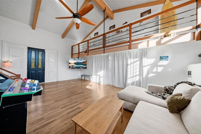 living room with beamed ceiling, ceiling fan, wood-type flooring, and high vaulted ceiling