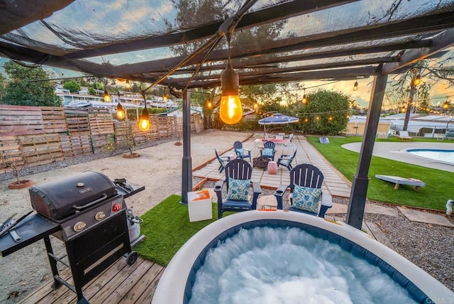 patio terrace at dusk with grilling area and a pergola