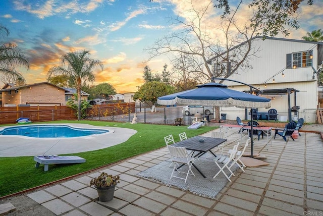 pool at dusk with a yard, a pergola, and a patio area