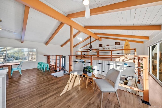 living area with ceiling fan, hardwood / wood-style floors, and vaulted ceiling with beams