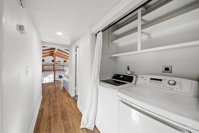 laundry room featuring washer and dryer and light hardwood / wood-style flooring