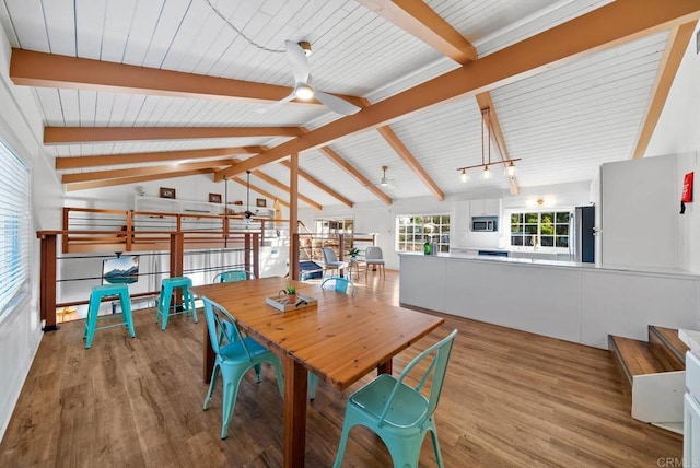 dining room featuring vaulted ceiling with beams, ceiling fan, and light wood-type flooring