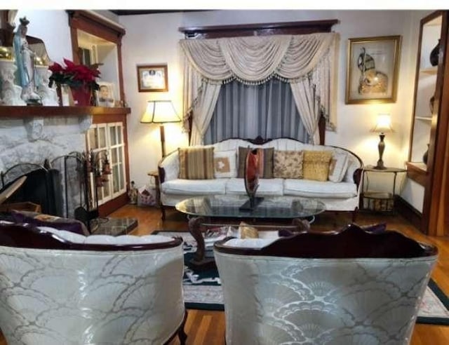 living room with hardwood / wood-style flooring and a large fireplace