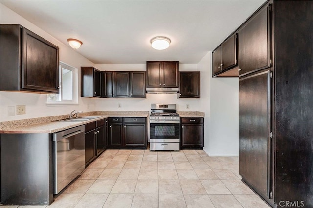 kitchen with light tile patterned floors, appliances with stainless steel finishes, light countertops, under cabinet range hood, and a sink