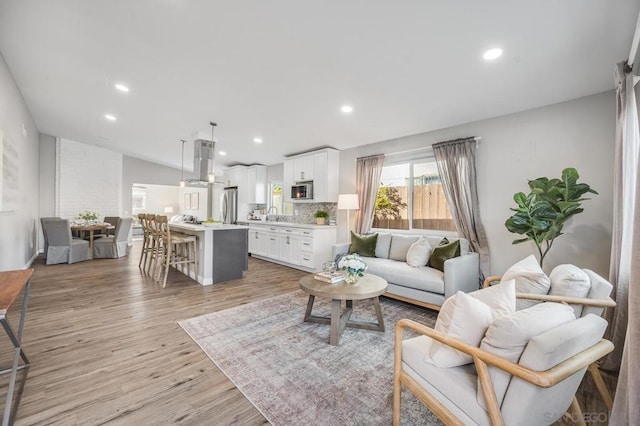 living room with sink and light hardwood / wood-style floors