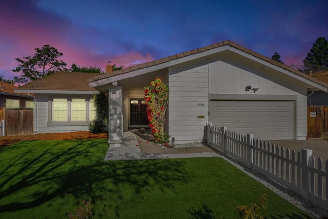 ranch-style home with a garage and a lawn