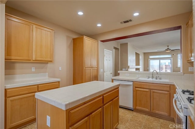 kitchen featuring a kitchen island, tile countertops, sink, light brown cabinets, and white appliances