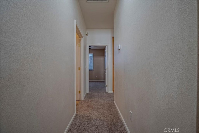 corridor featuring light colored carpet