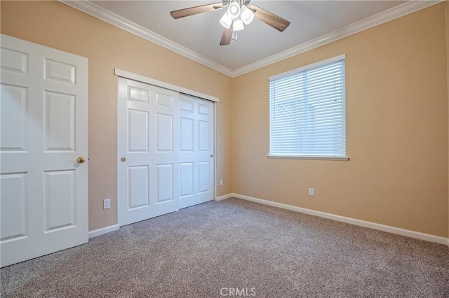 unfurnished bedroom featuring carpet floors, ornamental molding, a closet, and ceiling fan