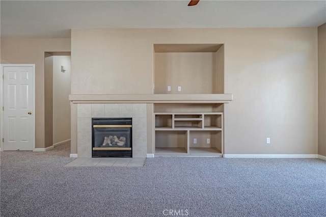 unfurnished living room with ceiling fan, light colored carpet, and a tile fireplace