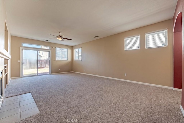 carpeted empty room with ceiling fan and a healthy amount of sunlight