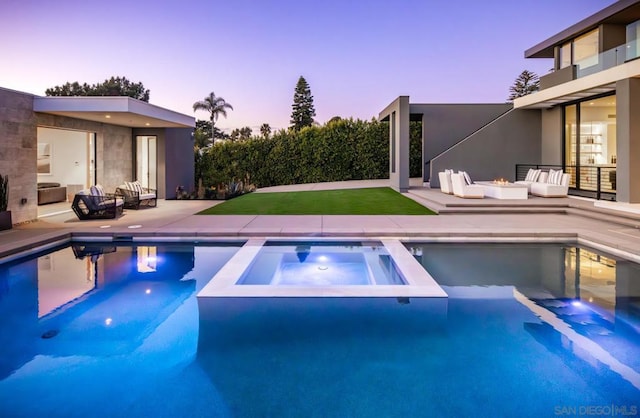 pool at dusk featuring an in ground hot tub, outdoor lounge area, and a patio