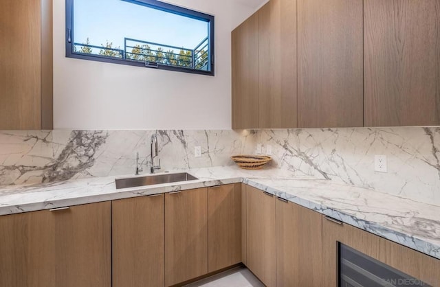 kitchen with light stone counters, sink, and tasteful backsplash