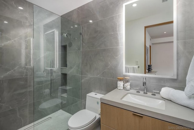 bathroom featuring tile walls, backsplash, vanity, a tile shower, and toilet