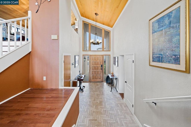 entrance foyer featuring high vaulted ceiling, light parquet flooring, and a chandelier