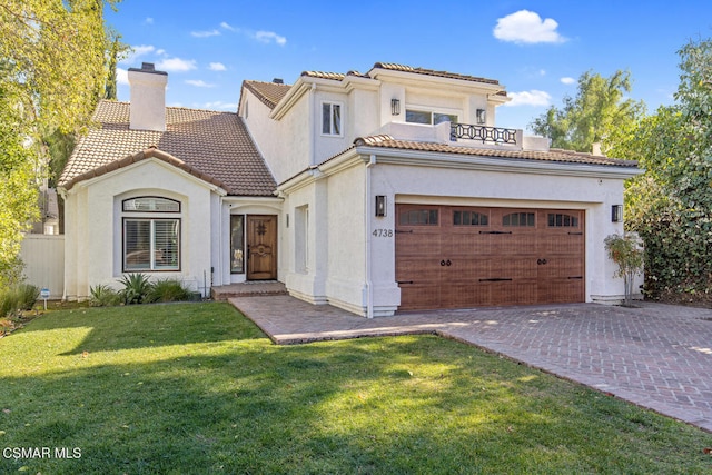 mediterranean / spanish-style home featuring a garage and a front lawn