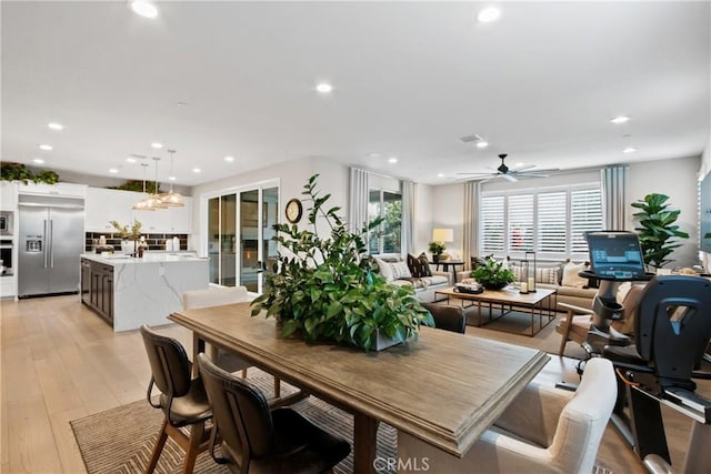 dining area with ceiling fan and light wood-type flooring