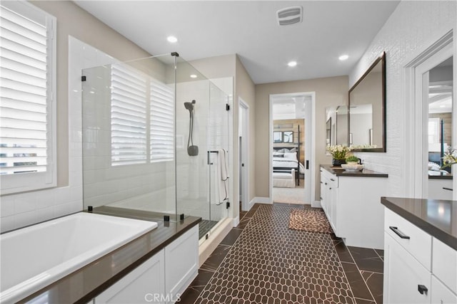 bathroom featuring tile patterned flooring, shower with separate bathtub, and vanity