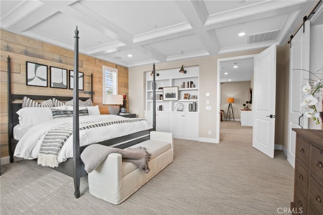 bedroom with a barn door, coffered ceiling, light colored carpet, and wooden walls