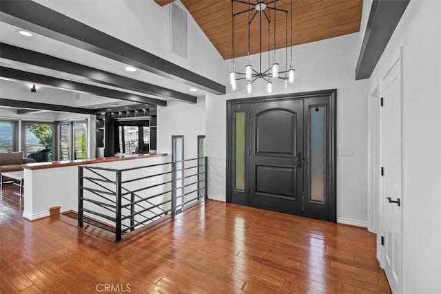 foyer entrance featuring beam ceiling, baseboards, and hardwood / wood-style flooring