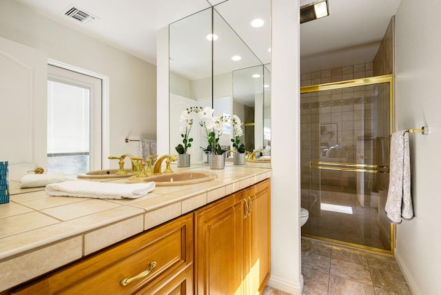 bathroom featuring vanity, toilet, and an enclosed shower