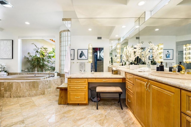 bathroom with vanity and a relaxing tiled tub