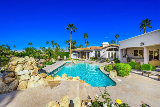 view of swimming pool featuring a patio and french doors