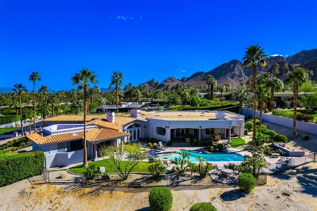 back of property featuring a mountain view and a patio area