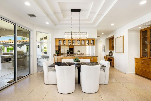 dining area featuring a raised ceiling and light tile patterned flooring