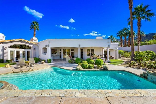 view of swimming pool with french doors and a patio area