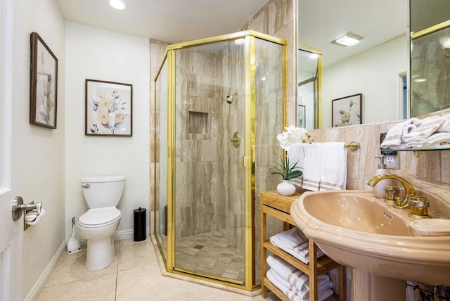 bathroom with toilet, a shower with door, and sink