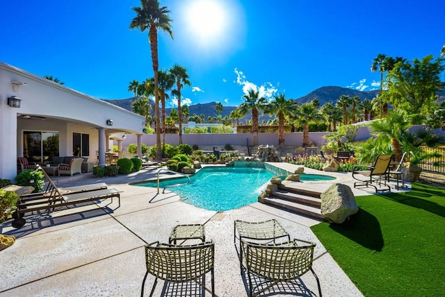 view of pool featuring a hot tub, a mountain view, and a patio area