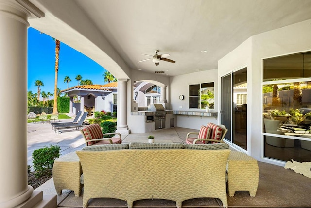 view of patio featuring a grill, ceiling fan, and an outdoor kitchen