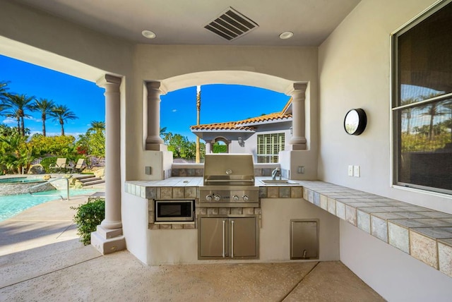 view of patio / terrace with grilling area and an outdoor kitchen