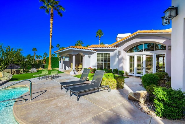 rear view of house featuring french doors and a patio area