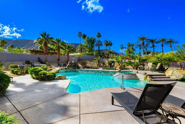 view of swimming pool featuring a mountain view, a patio area, and an in ground hot tub