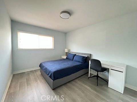 bedroom featuring wood finished floors and baseboards