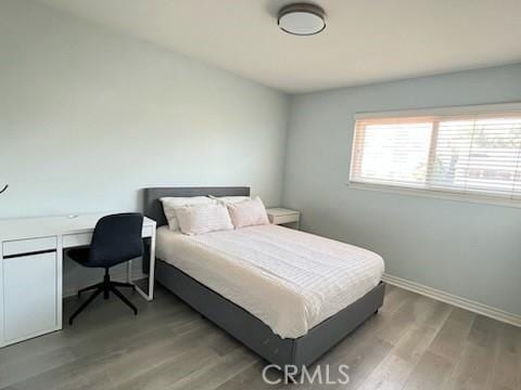 bedroom with baseboards and wood finished floors