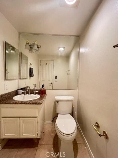 bathroom with vanity, tile patterned flooring, and toilet