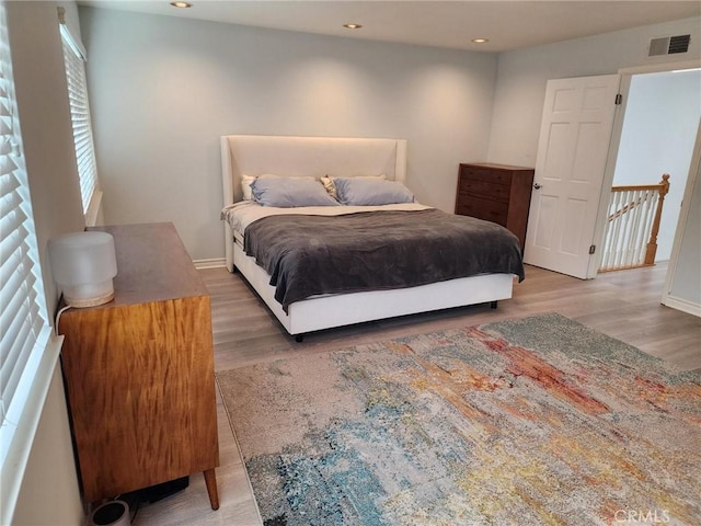 bedroom featuring baseboards, visible vents, wood finished floors, and recessed lighting