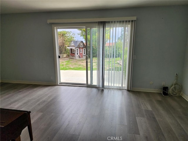 interior space featuring a wealth of natural light, wood finished floors, and baseboards